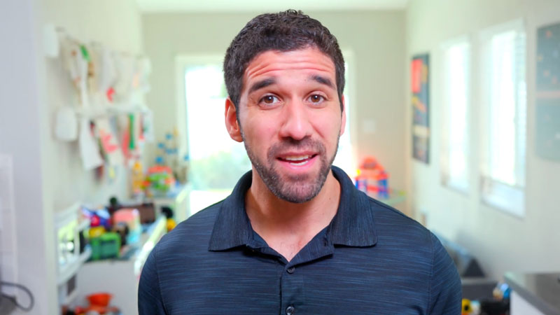 Man speaking to camera in colorful playroom background